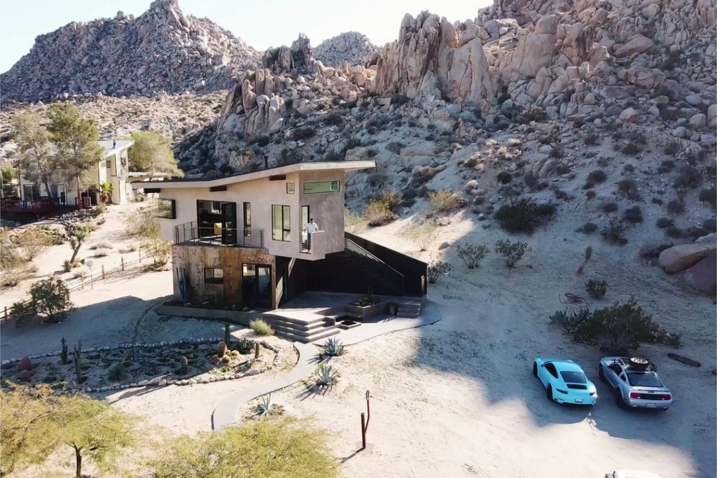 Maison dans le désert avec voiture de luxe